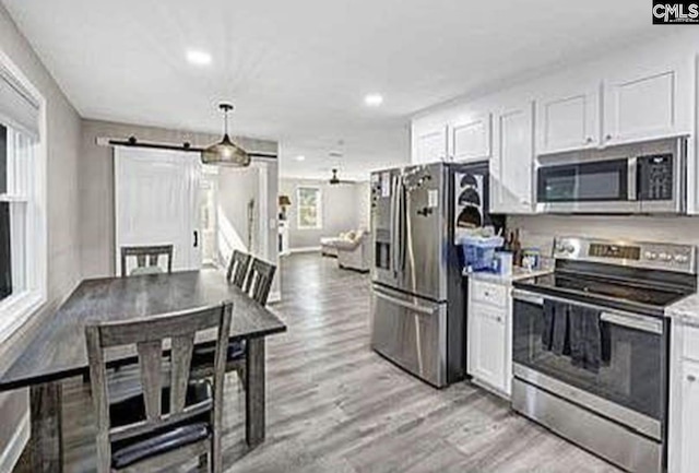 kitchen featuring appliances with stainless steel finishes, light countertops, and white cabinetry