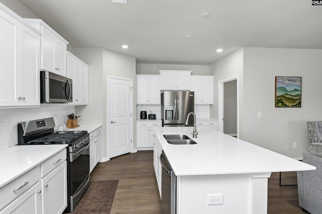 kitchen with a center island with sink, appliances with stainless steel finishes, light countertops, and a sink