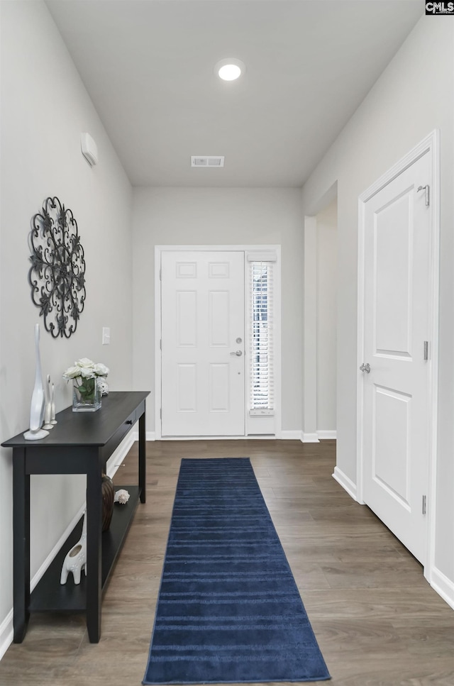 entrance foyer with dark wood-type flooring, visible vents, and baseboards