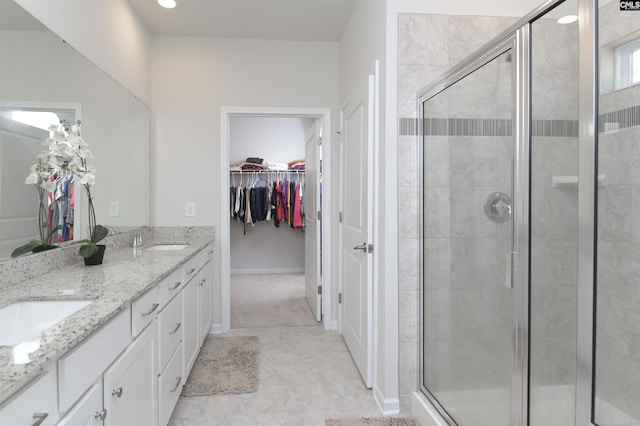 full bath with a stall shower, a spacious closet, and a sink