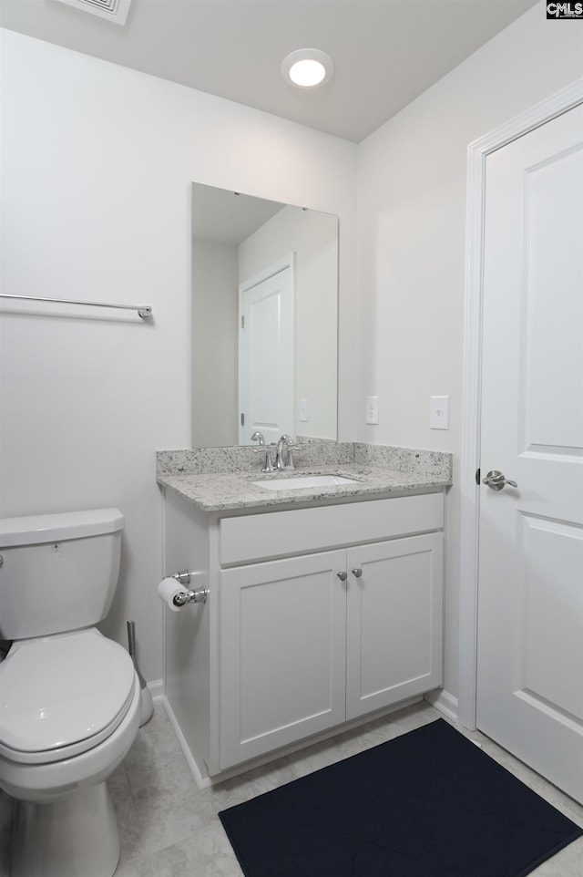 half bathroom featuring baseboards, vanity, and toilet