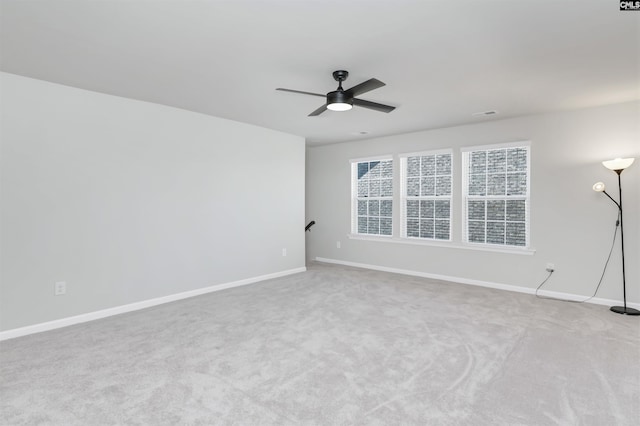 unfurnished room featuring a ceiling fan, light carpet, and baseboards