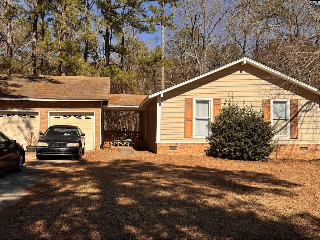 view of front facade featuring crawl space, driveway, and a garage