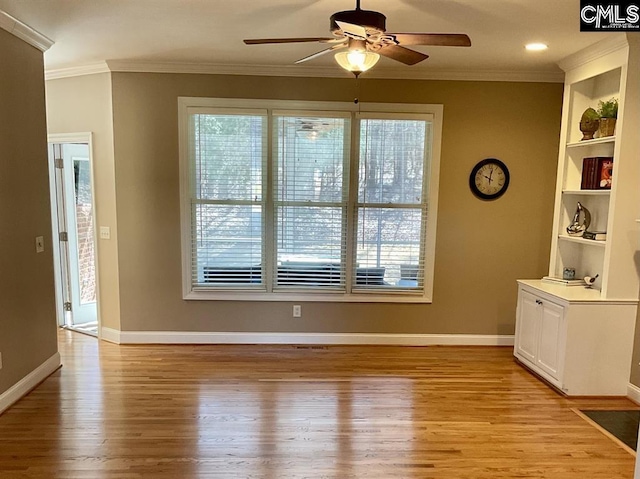 unfurnished dining area featuring baseboards, light wood finished floors, plenty of natural light, and crown molding