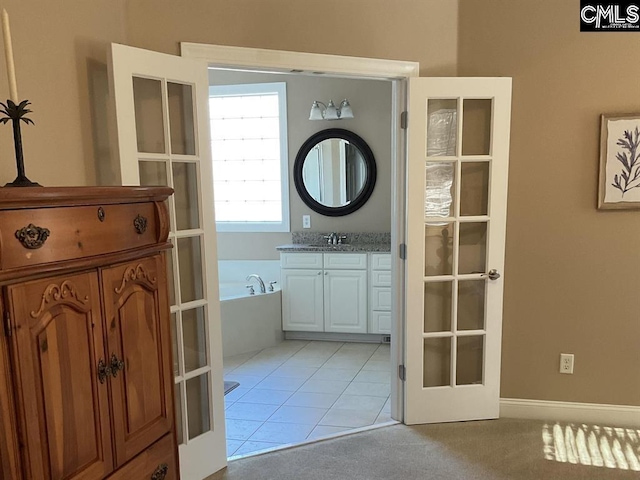 bathroom featuring french doors, tile patterned flooring, a garden tub, and vanity