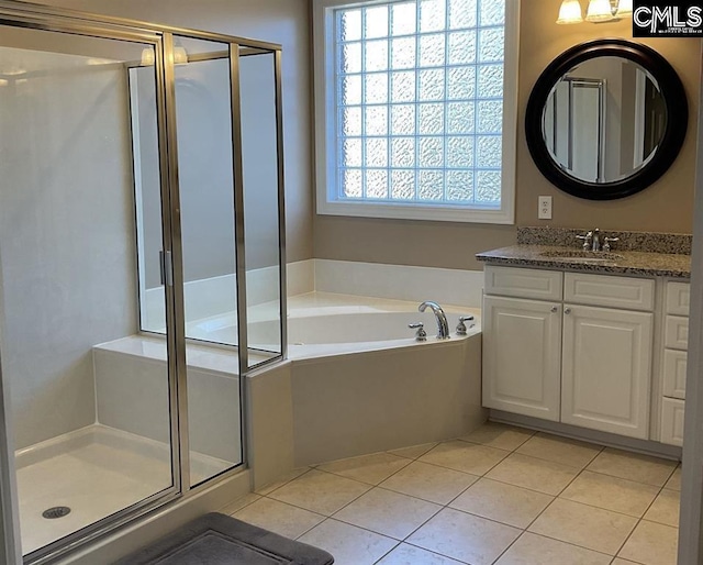 full bathroom with a shower stall, vanity, a bath, and tile patterned floors