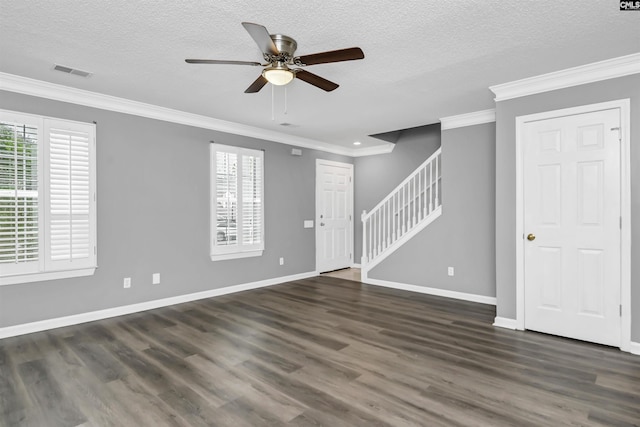 spare room with crown molding, dark wood finished floors, visible vents, stairway, and baseboards