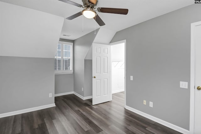 additional living space featuring dark wood-type flooring, vaulted ceiling, baseboards, and ceiling fan