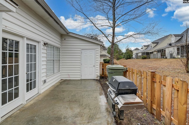 view of patio with fence, grilling area, and central AC unit