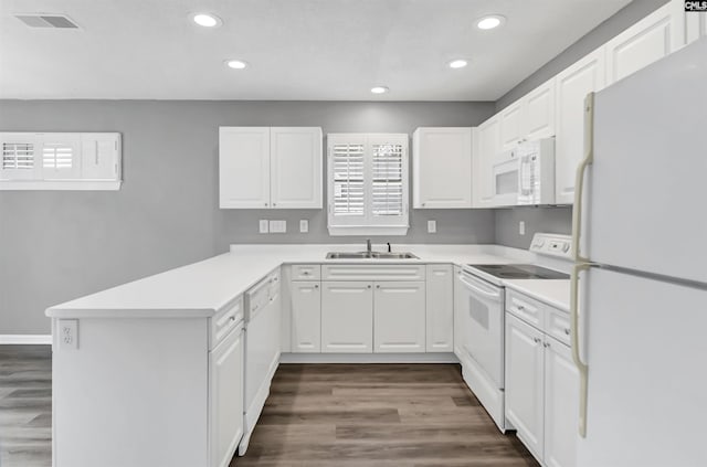 kitchen with light countertops, visible vents, white cabinetry, white appliances, and a peninsula