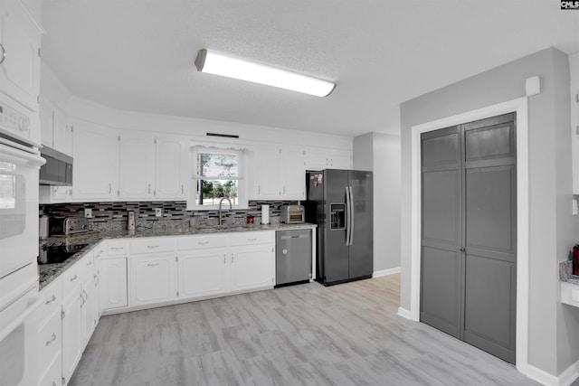 kitchen featuring stainless steel appliances, a sink, and white cabinetry