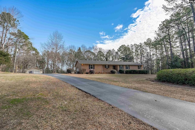 ranch-style home with an outdoor structure and a front yard