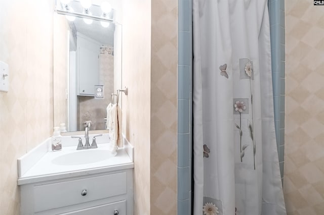 bathroom featuring a tile shower and vanity