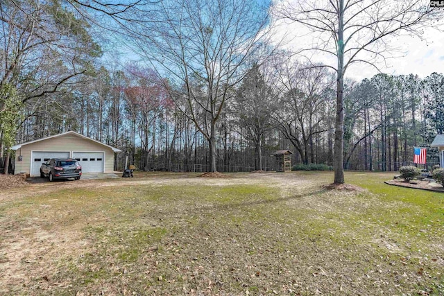 view of yard with a garage and an outbuilding