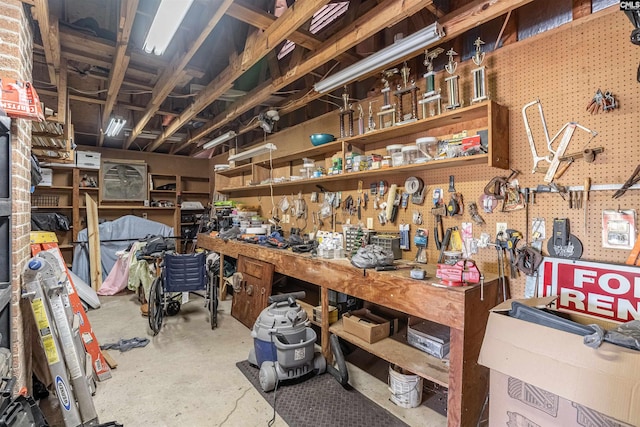 miscellaneous room with concrete flooring and a workshop area