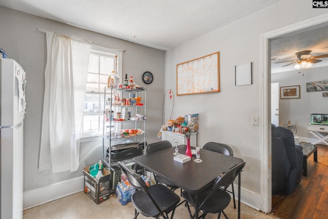 dining area with ceiling fan, a textured ceiling, and baseboards