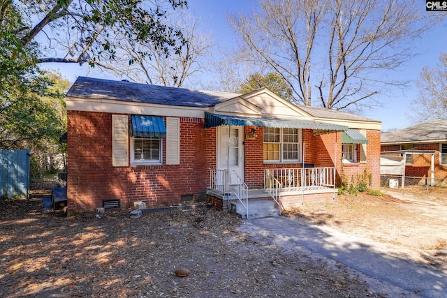 bungalow-style home featuring crawl space, fence, and brick siding