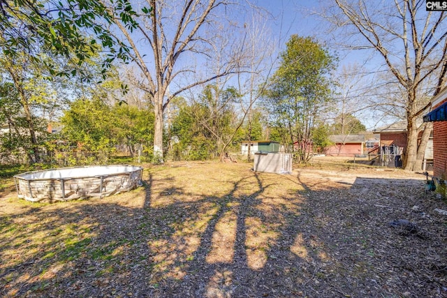 view of yard with an empty pool