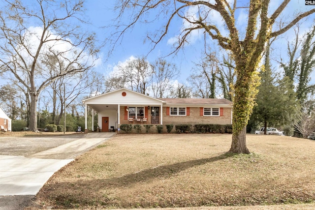 view of front facade with a porch, brick siding, concrete driveway, a carport, and a front yard