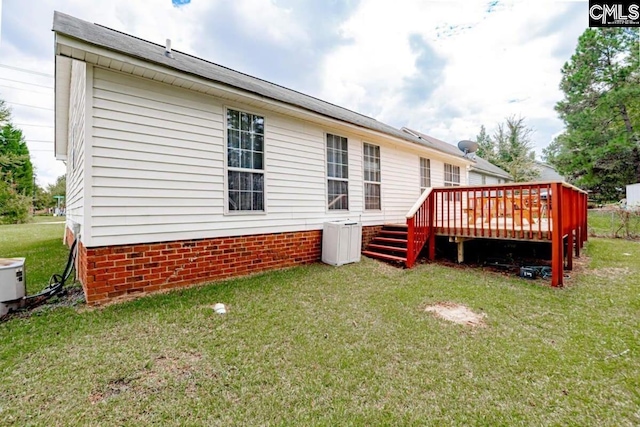 rear view of property featuring a deck and a yard