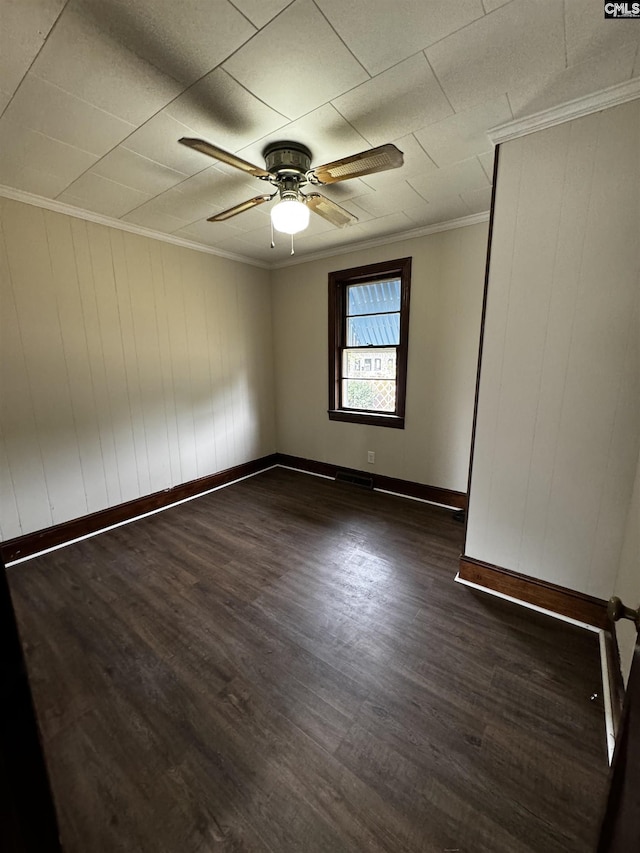 unfurnished room with ceiling fan, baseboards, dark wood-type flooring, and crown molding