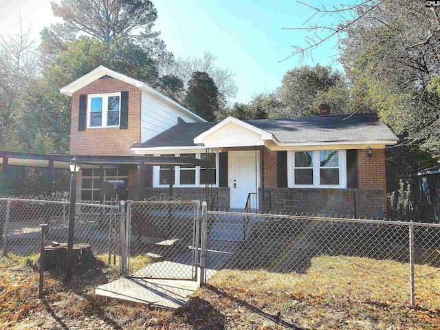 view of front of home featuring stone siding, a fenced front yard, a gate, and brick siding