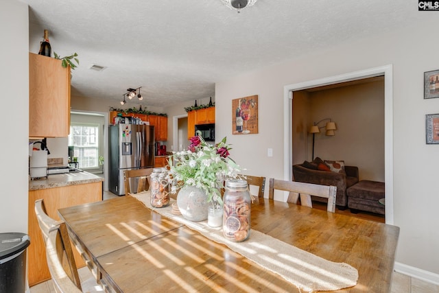 dining room featuring visible vents and a textured ceiling