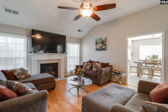 living room featuring lofted ceiling, visible vents, and plenty of natural light