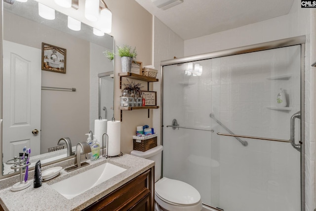 full bath featuring toilet, a shower with shower door, and vanity