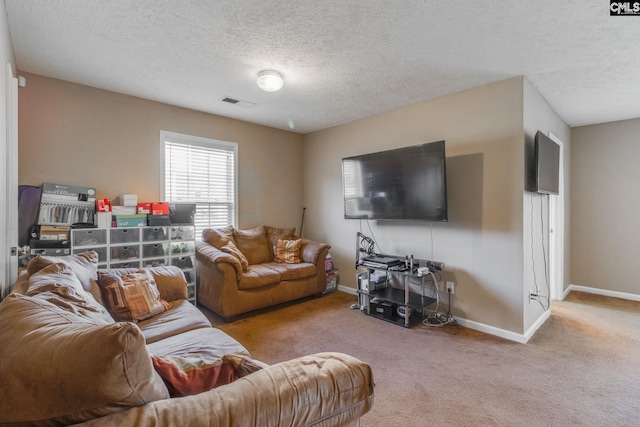 living room featuring light colored carpet, visible vents, baseboards, and a textured ceiling