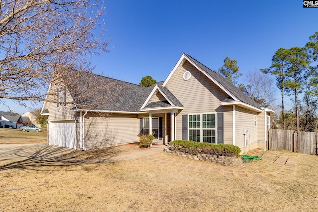 view of front of home featuring a front yard, fence, and an attached garage