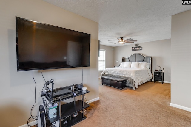 bedroom featuring a ceiling fan, a textured ceiling, baseboards, and carpet flooring