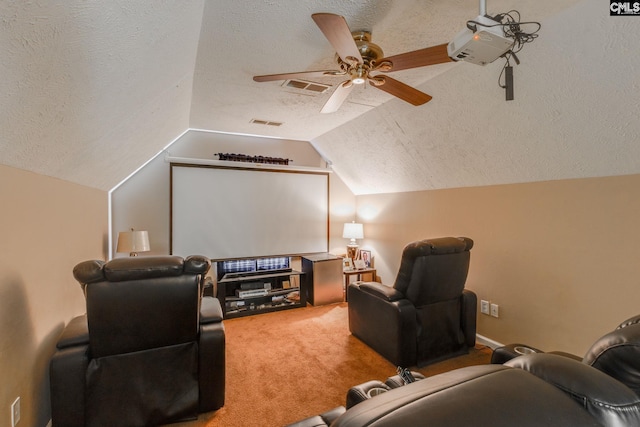 carpeted cinema featuring visible vents, vaulted ceiling, a textured ceiling, and ceiling fan