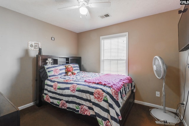 bedroom with ceiling fan, dark colored carpet, visible vents, and baseboards