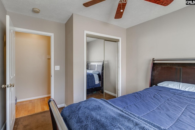 bedroom with a ceiling fan, a closet, a textured ceiling, and baseboards