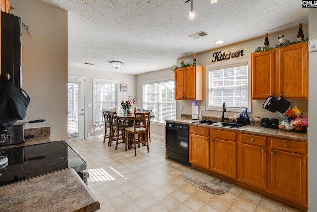 kitchen with electric stove, dark countertops, visible vents, a sink, and dishwasher