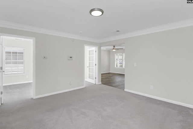 spare room featuring baseboards, dark carpet, and crown molding