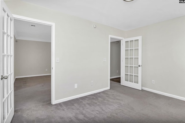 carpeted empty room featuring french doors, visible vents, and baseboards