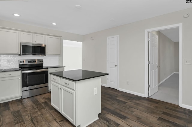 kitchen featuring appliances with stainless steel finishes, dark countertops, and white cabinetry