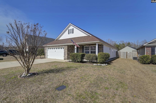 traditional-style home featuring concrete driveway, a front lawn, an attached garage, and fence