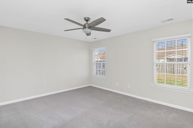 spare room with a ceiling fan, carpet, visible vents, and baseboards