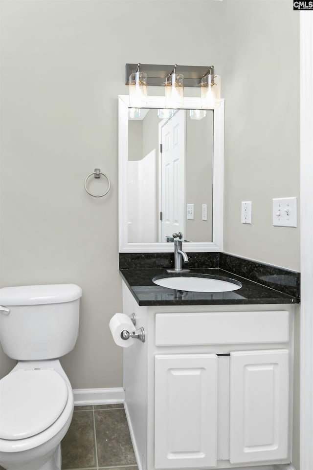 bathroom with toilet, tile patterned flooring, baseboards, and vanity