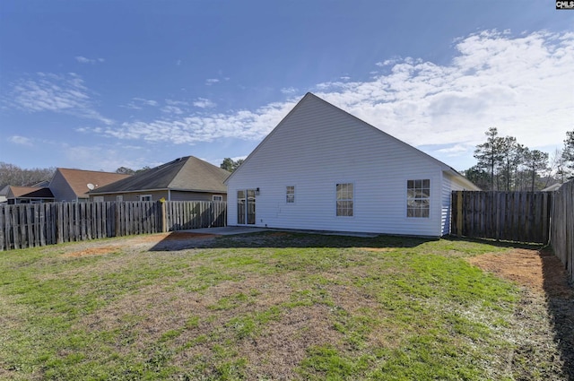 back of house featuring a yard and a fenced backyard