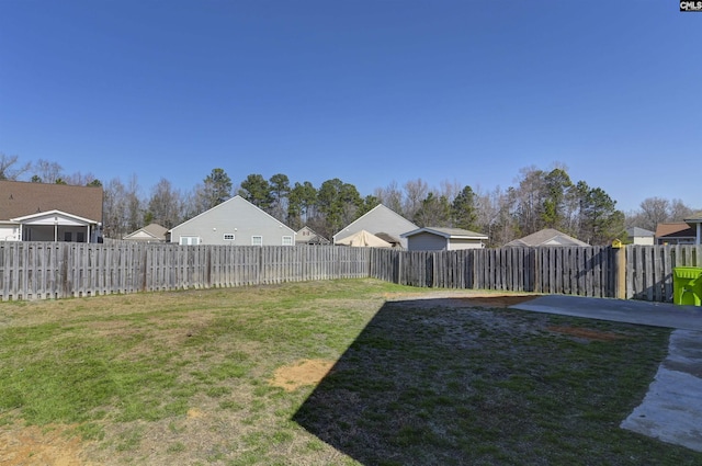 view of yard featuring a patio, a fenced backyard, and a residential view