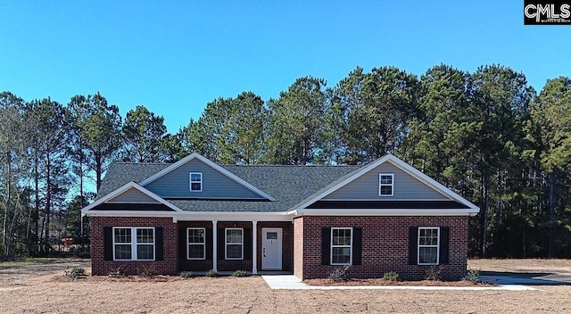 view of front of home with covered porch and brick siding