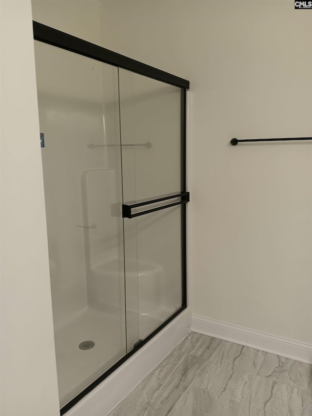 full bath featuring an enclosed shower and baseboards