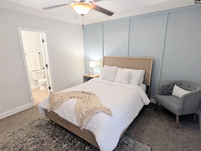 carpeted bedroom featuring ceiling fan, baseboards, connected bathroom, and a decorative wall