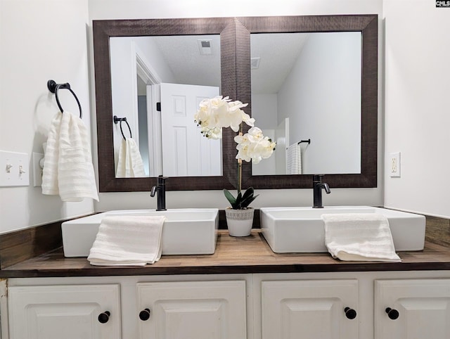 bathroom featuring a sink and double vanity