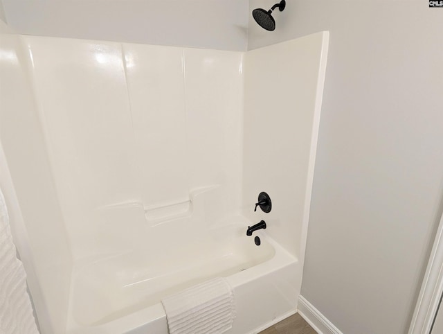 bathroom with bathtub / shower combination and baseboards