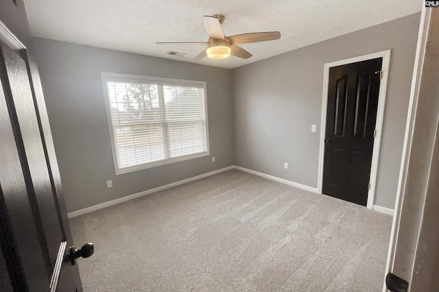 unfurnished bedroom featuring visible vents, baseboards, ceiling fan, a textured ceiling, and carpet floors